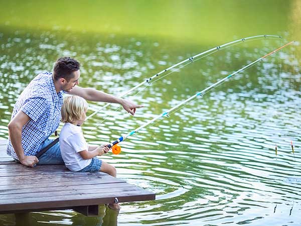 Man and boy fishing from a dock