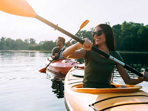 Man and woman paddling kayaks